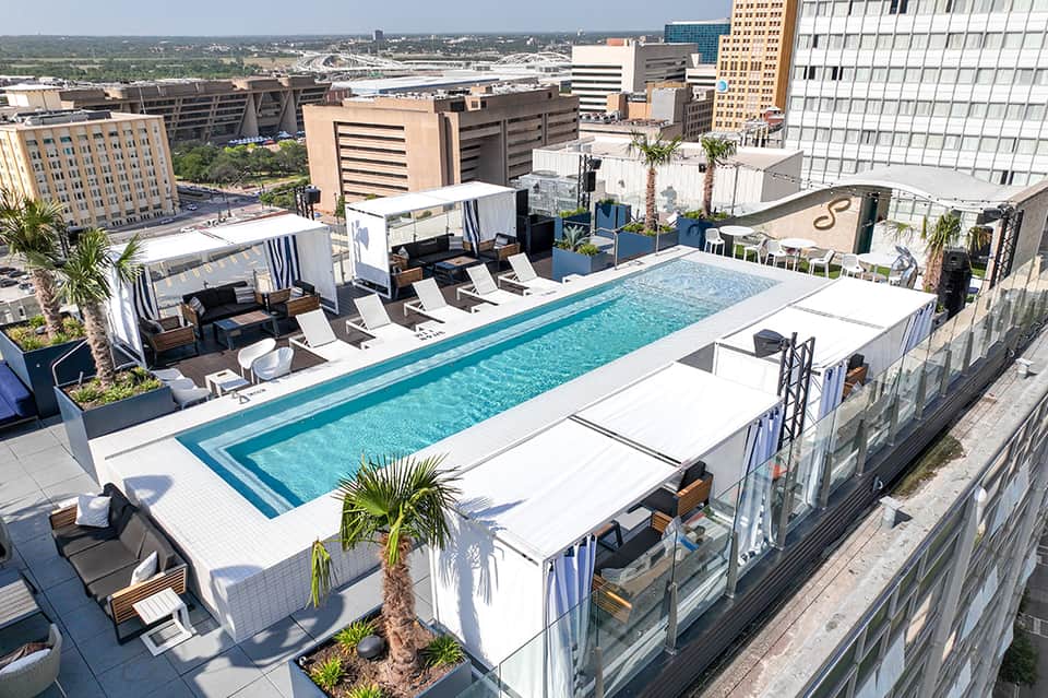 Modern rooftop pool on high-rise building with city skyline and river views