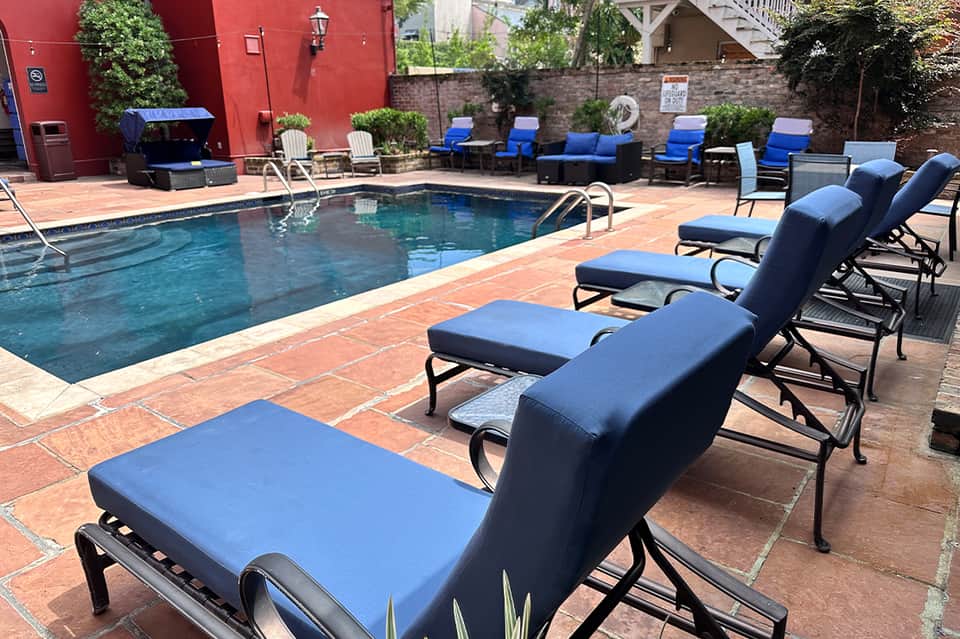 Resort pool deck with blue lounge chairs and red brick patio