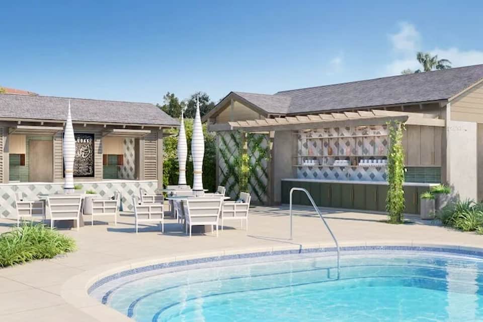 Resort pool area with white lounge chairs, pergola shade structures, and modern poolside amenities
