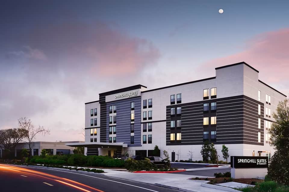 SpringHill Suites hotel exterior at dusk with illuminated windows and landscaping