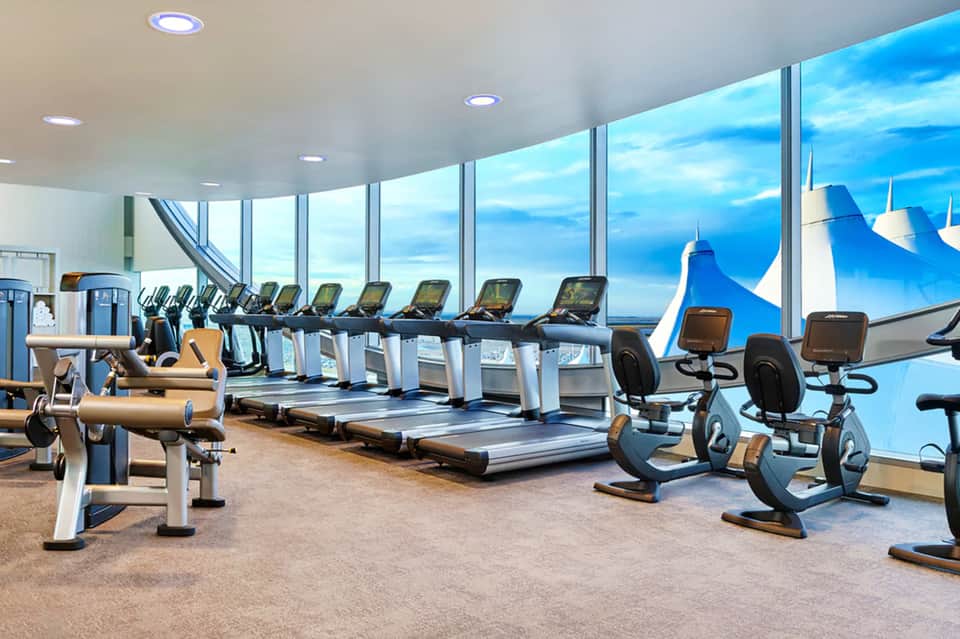 Fitness center with treadmills and exercise bikes overlooking mountains through floor-to-ceiling windows