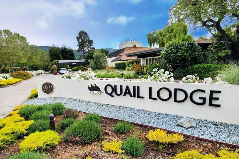 Quail Lodge resort entrance with manicured landscaping and mountain views