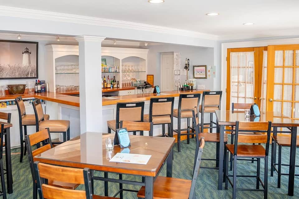 Casual dining area with wooden tables, bar counter, and orange accents