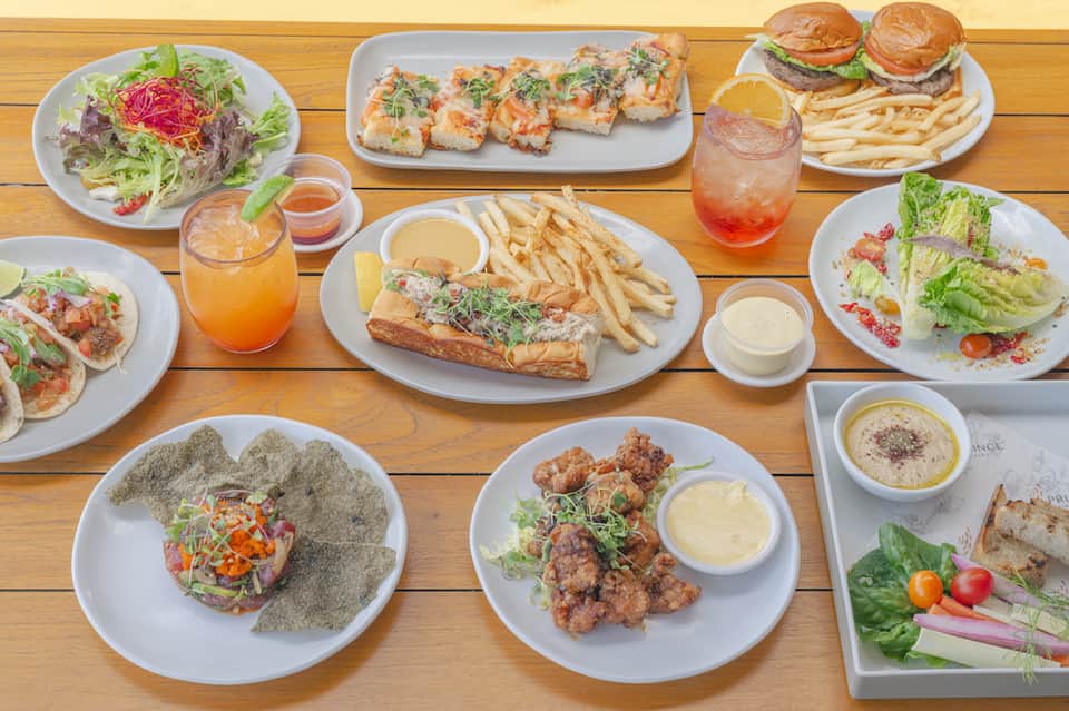 Assorted seafood and salad dishes with tropical cocktails on wooden table