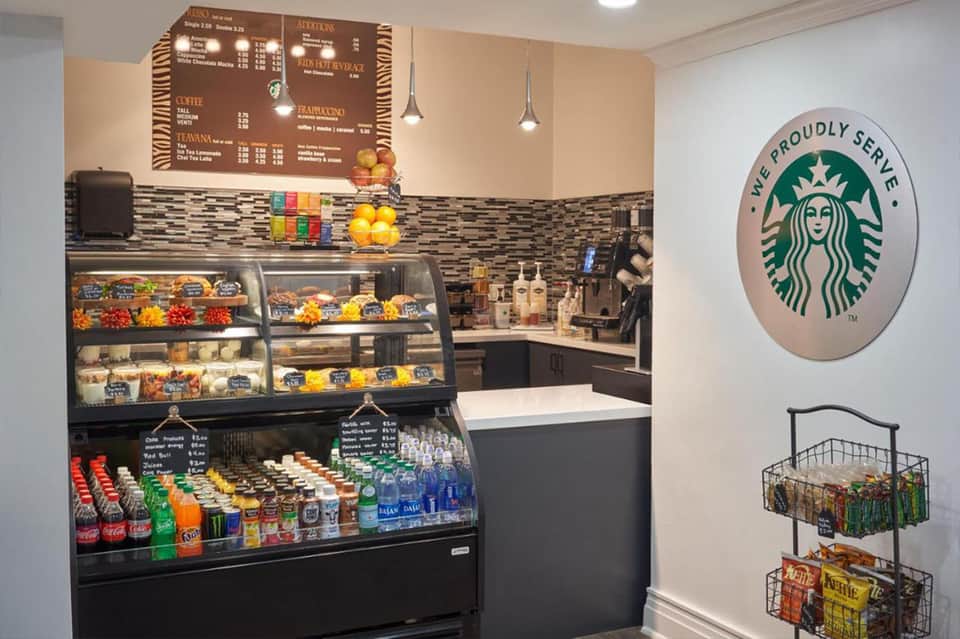 Starbucks café interior with menu board, pastry display case, and beverage cooler