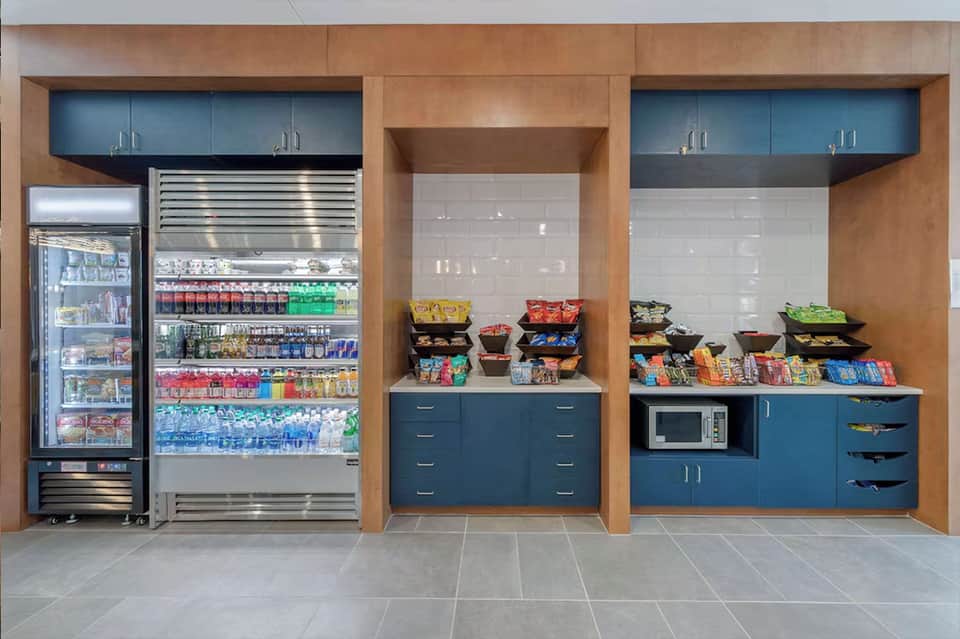 Hotel convenience store with refrigerated beverages, snacks, and microwave