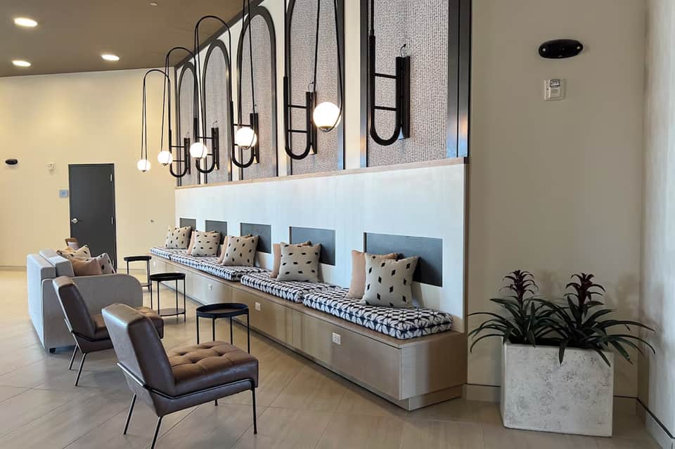 Modern hotel lobby lounge with bench seating, pendant lights, and contemporary furnishings