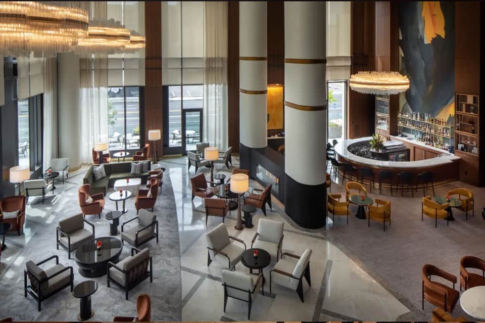 Modern luxury hotel lobby with cylindrical columns, bar, and seating areas