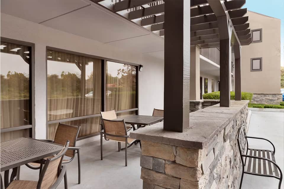 Modern patio with pergola, dining table, and stone fireplace