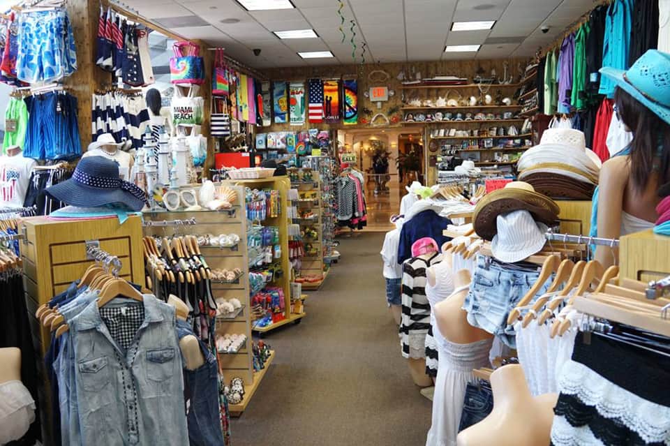 Colorful beachwear boutique interior with clothing racks, mannequins, and souvenir displays