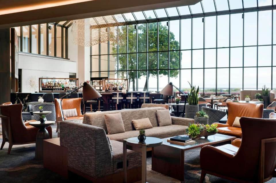 Modern lounge with floor-to-ceiling windows, bar, fireplace, and contemporary furnishings