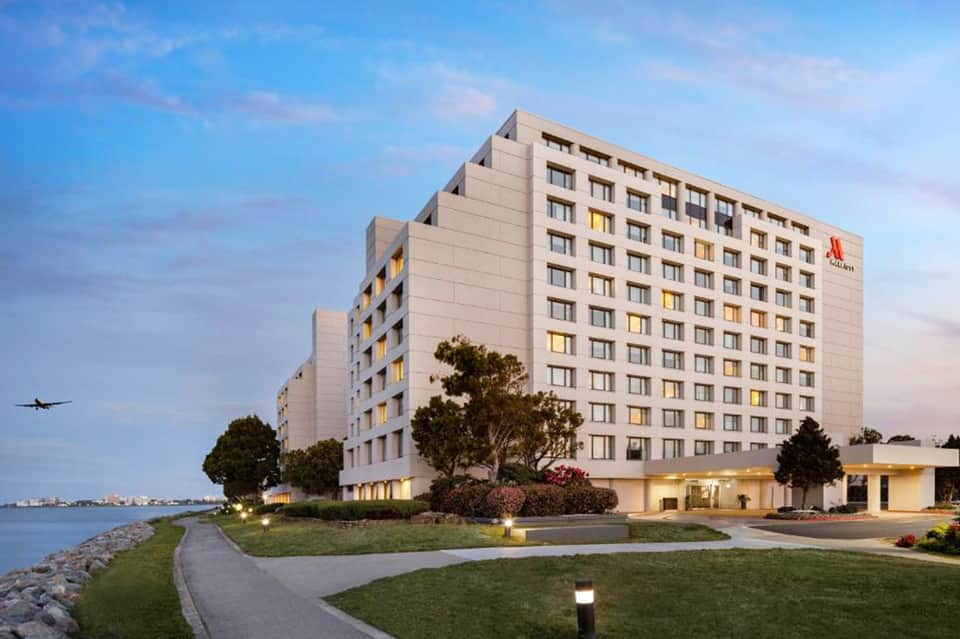 Waterfront Marriott hotel exterior at dusk with manicured lawn and Rocky coastline