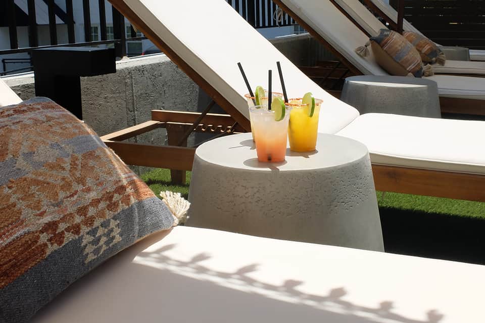Poolside cocktails on table overlooking ocean from resort deck