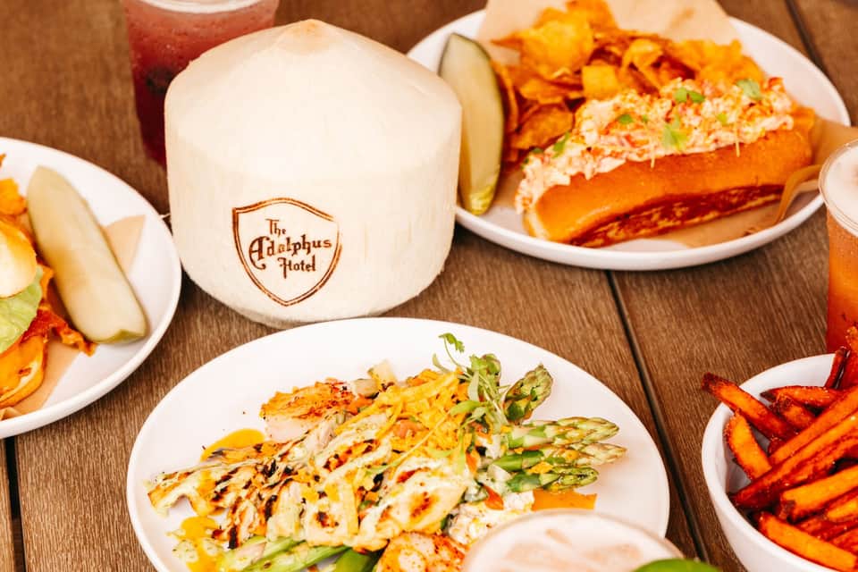 Plated seafood dishes and appetizers at The Adolphus Hotel restaurant with branded napkin holder