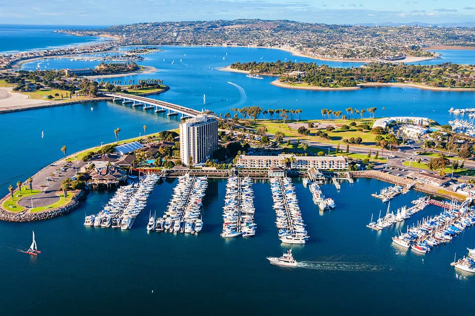 Aerial view of marina with organized boat docks and surrounding coastal landscape with bridges