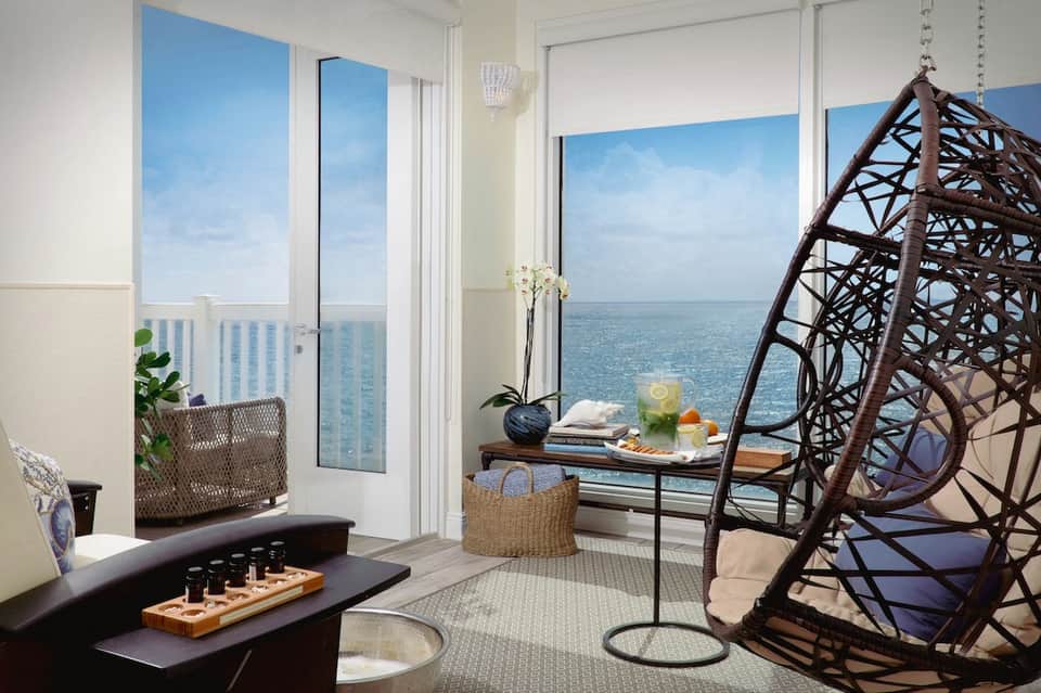 Oceanfront luxury suite with hanging chair, ocean view, and contemporary furnishings