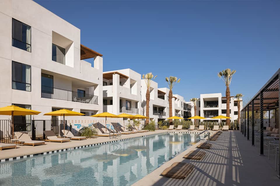 Modern white residential buildings with palm trees and pool area