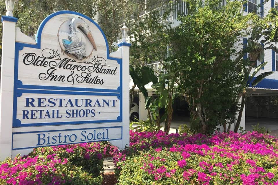 Olde Marco Island Inn & Suites entrance sign with colorful flower beds