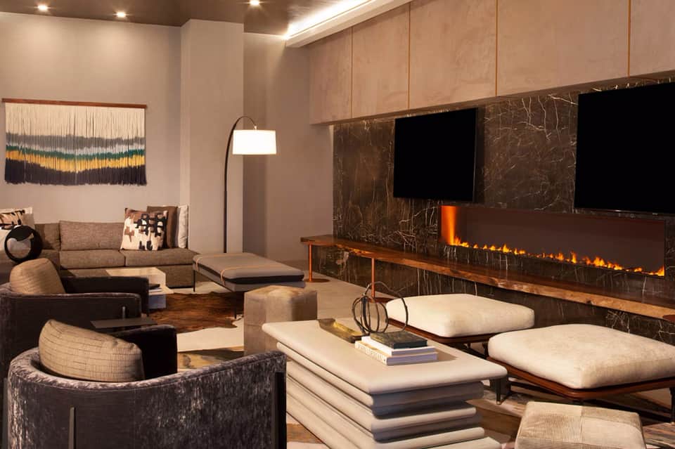 Contemporary living room with fireplace, neutral furnishings, and entertainment center with TV