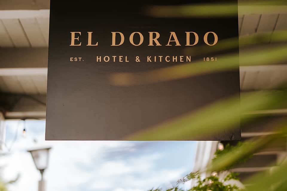 El Dorado Hotel & Kitchen signage established 1851 with blurred garden background