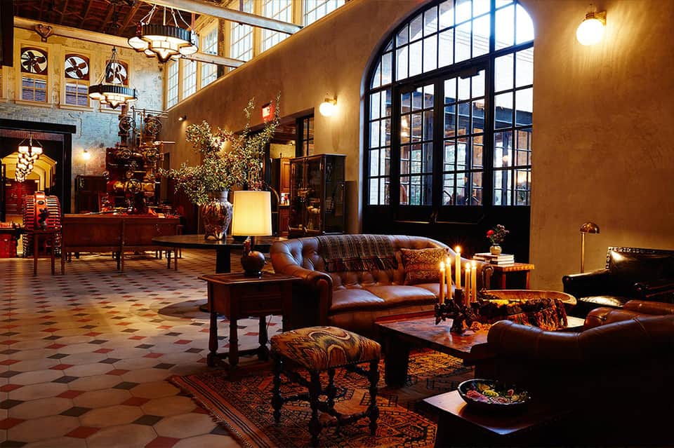 Elegant hotel lobby with leather furniture, fireplace, and arched windows