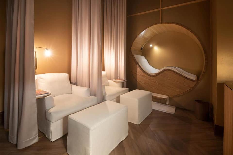 Spa relaxation room with modern wooden pod seating and warm ambient lighting