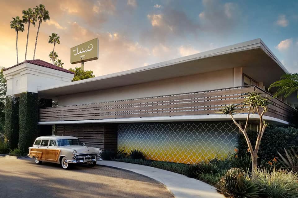 Retro mid-century modern building with vintage car and palm trees