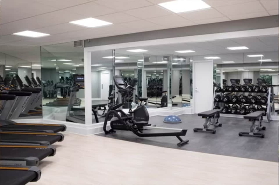 Modern fitness center with treadmills, stationary bikes, and mirrored walls