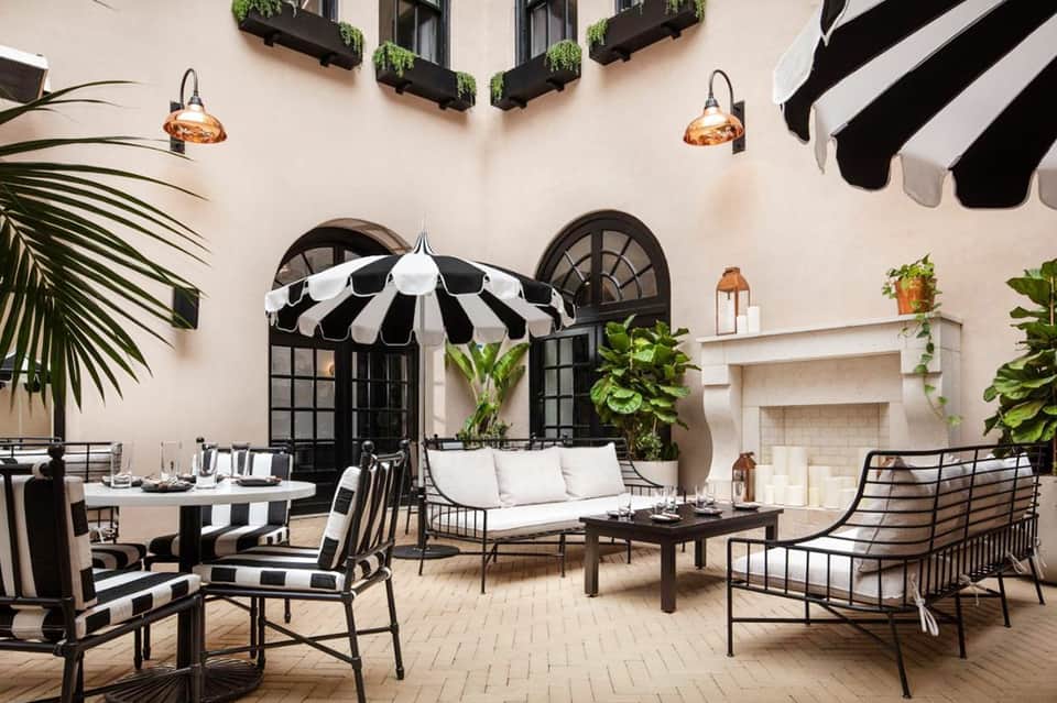 Elegant courtyard patio with black and white striped umbrella and seating