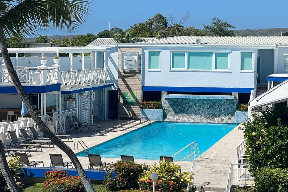 Modern white and blue mobile home with private pool and palm trees in sunny resort setting
