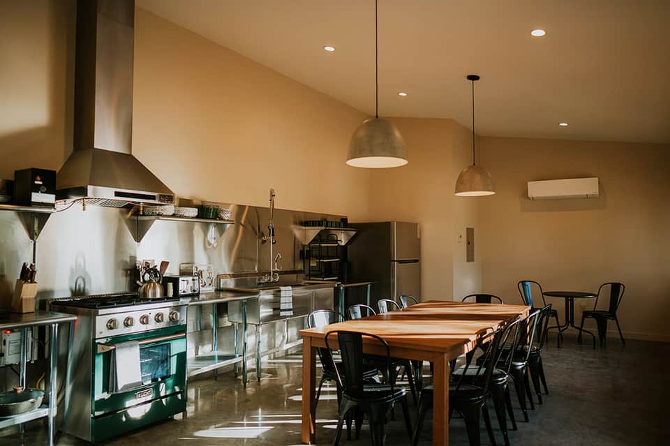 Modern open kitchen and dining area with stainless steel appliances and pendant lighting