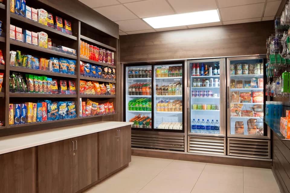 Convenience store interior with shelves of snacks and refrigerated beverages