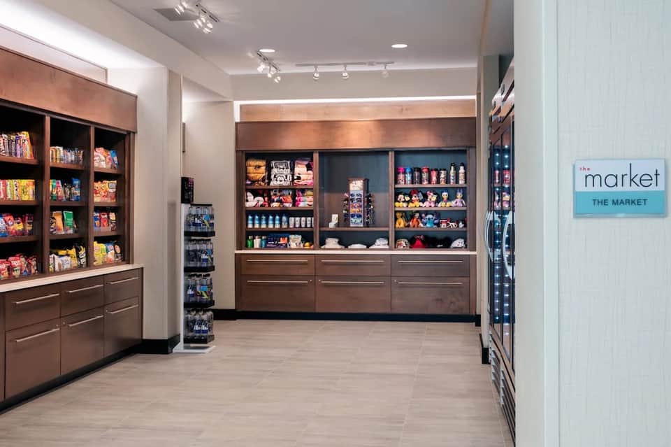 Modern gift shop interior with brown wooden display cabinets and shelving units stocked with merchandise
