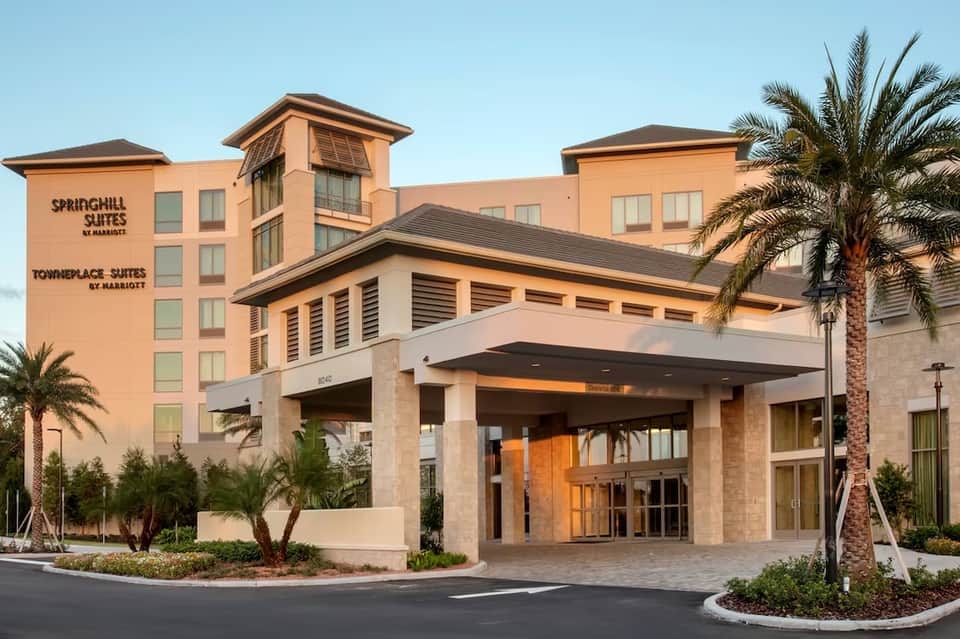 Peach-colored Springhill Suites and Towneplace Suites hotel exterior with palm trees and covered entrance