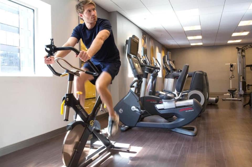 Resort fitness center with stationary bikes, exercise equipment, and bright natural light from windows