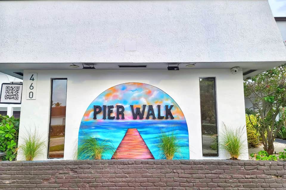 White storefront with colorful pier mural artwork and address number 460