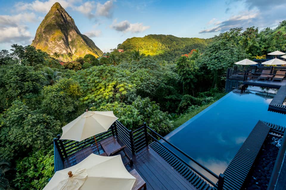 Infinity pool overlooking lush jungle and distinctive peaked mountain formation during daytime
