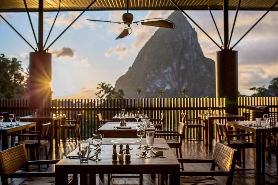 Fine dining restaurant terrace with dramatic mountain backdrop at sunset