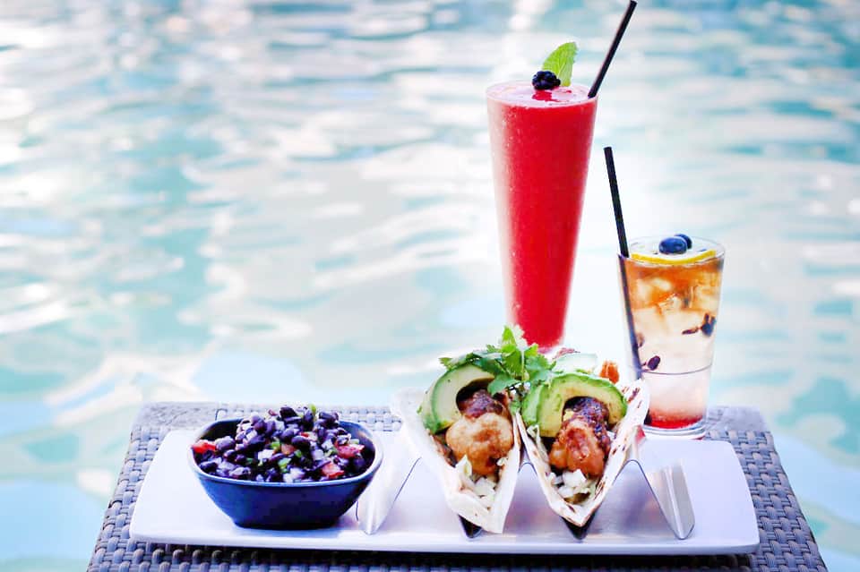 Poolside dining with fresh tacos, berry salad, and colorful tropical cocktails