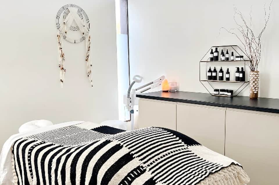 Minimalist bedroom with striped black and white bedding, dream catcher wall art, and modern furnishings