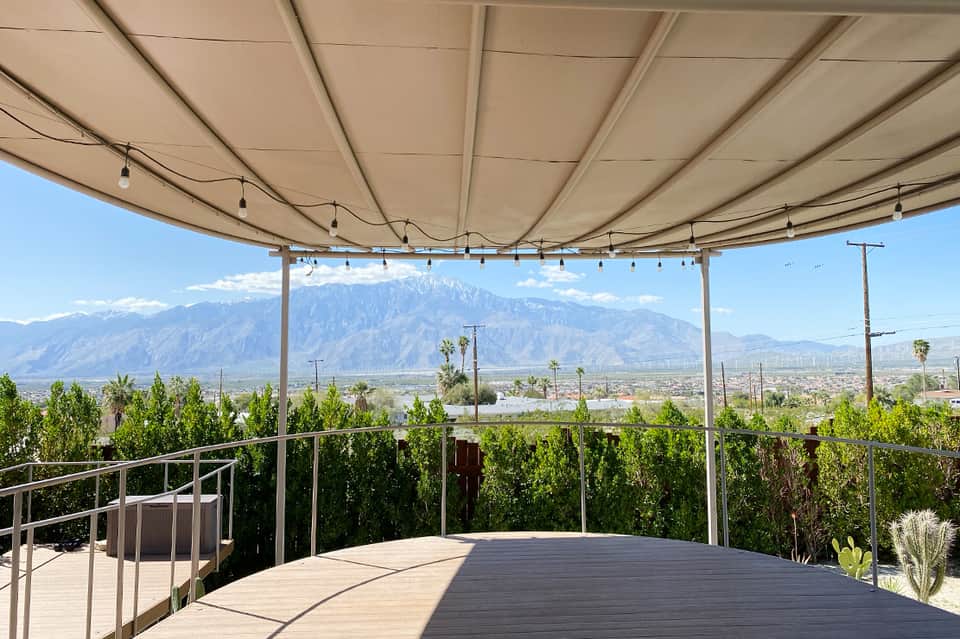 Desert mountain vista from rooftop terrace with shade structure, lounge seating, and scenic valley views