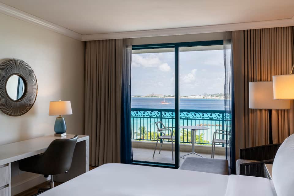 Oceanview hotel room with balcony, modern furnishings, and coastal landscape