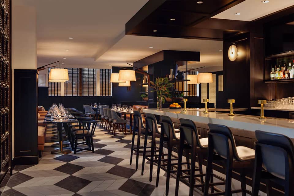 Upscale bar and restaurant with black modern design, ambient lighting, and long counter seating