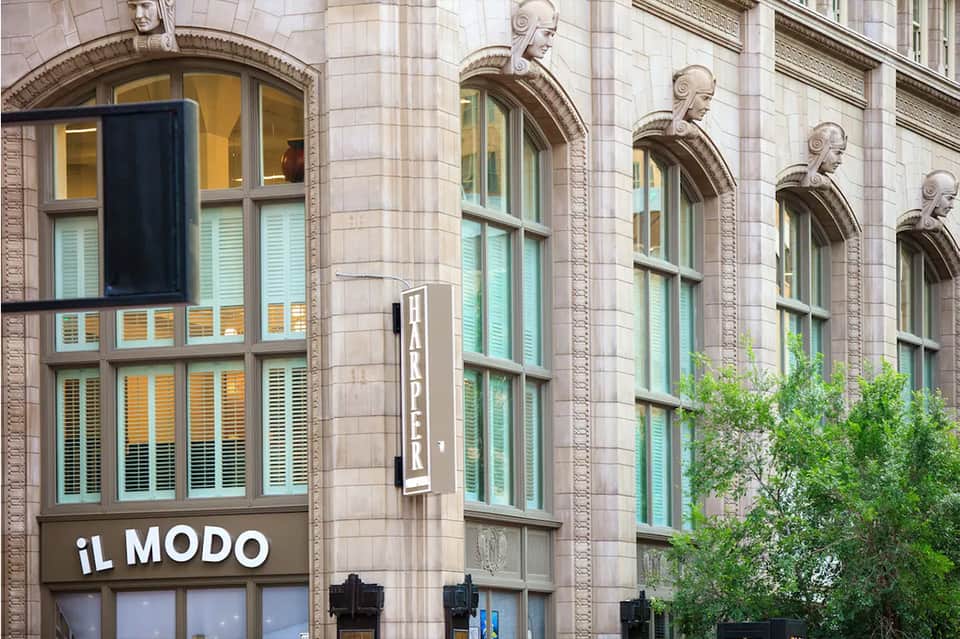Historic building facade with arched windows, decorative stone carvings, and turquoise shutters
