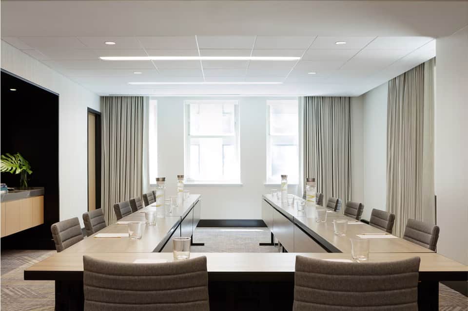 Corporate meeting room with U-shaped table setup and floor-to-ceiling windows