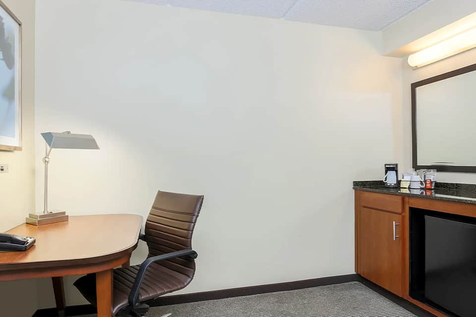 Hotel consultation room with desk, chair, mirror, and professional lighting