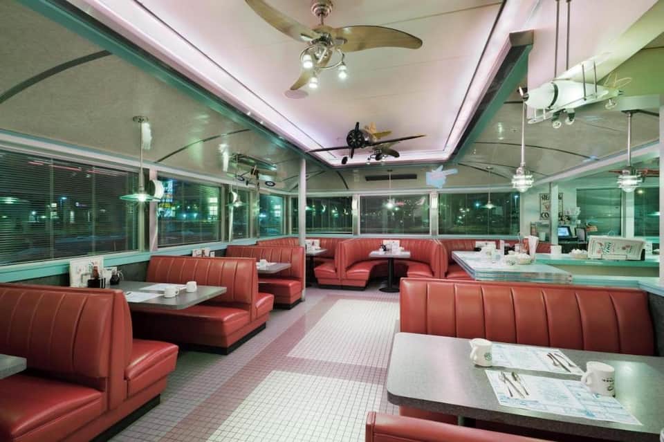 Retro-style diner with red vinyl booth seating, turquoise accents, and large windows