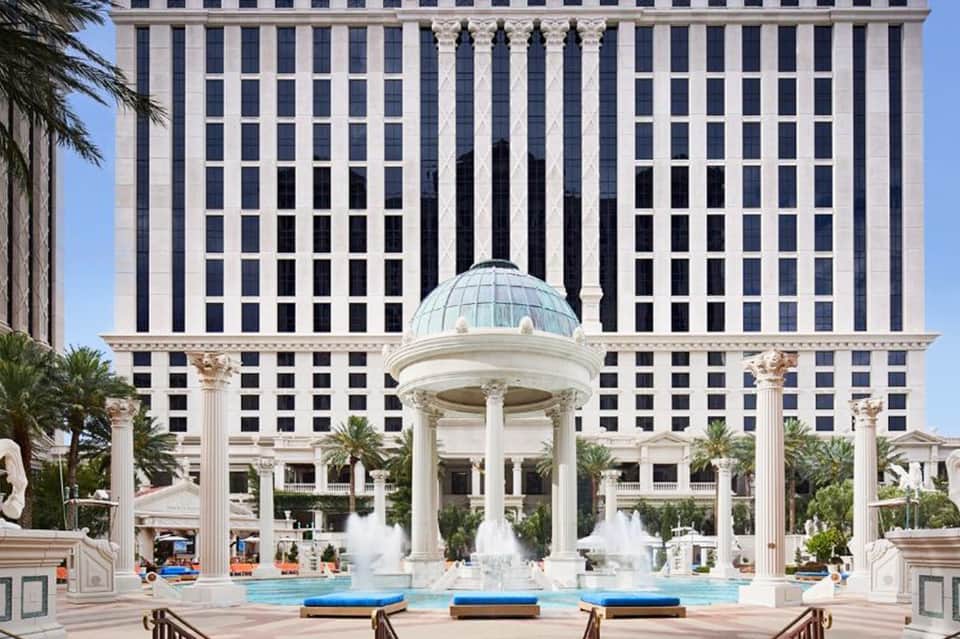 Luxury resort courtyard with classical dome structure, fountains, palm trees, and columned architecture