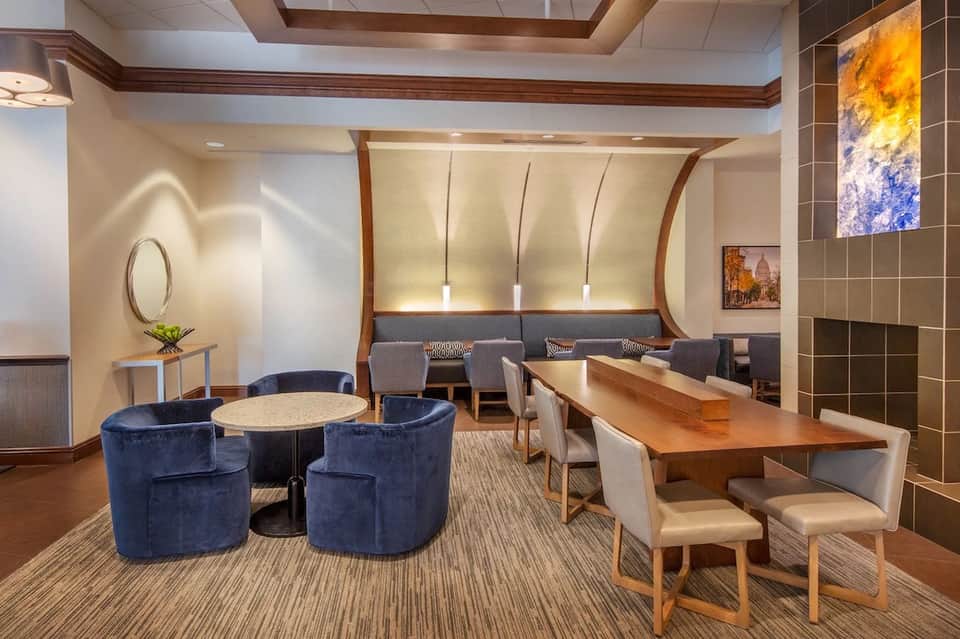 Modern hotel lobby lounge with blue curved chairs, wooden accents, and contemporary artwork