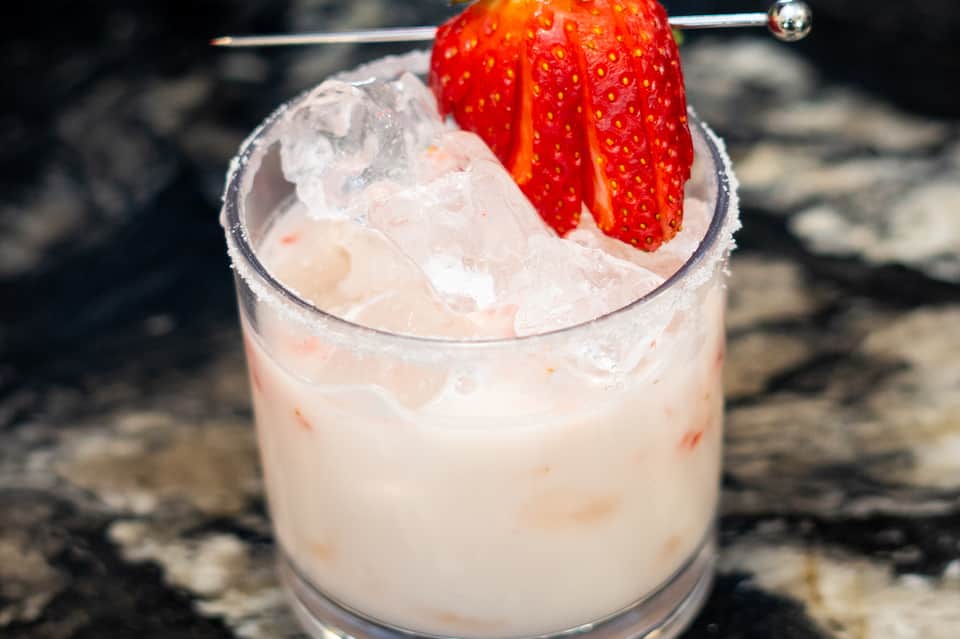Strawberry garnish on frozen cocktail with ice, close-up shot